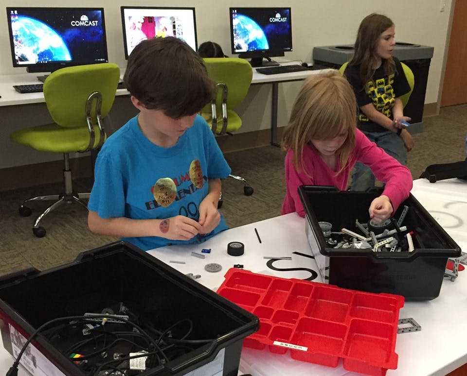 Children working with small parts at a table