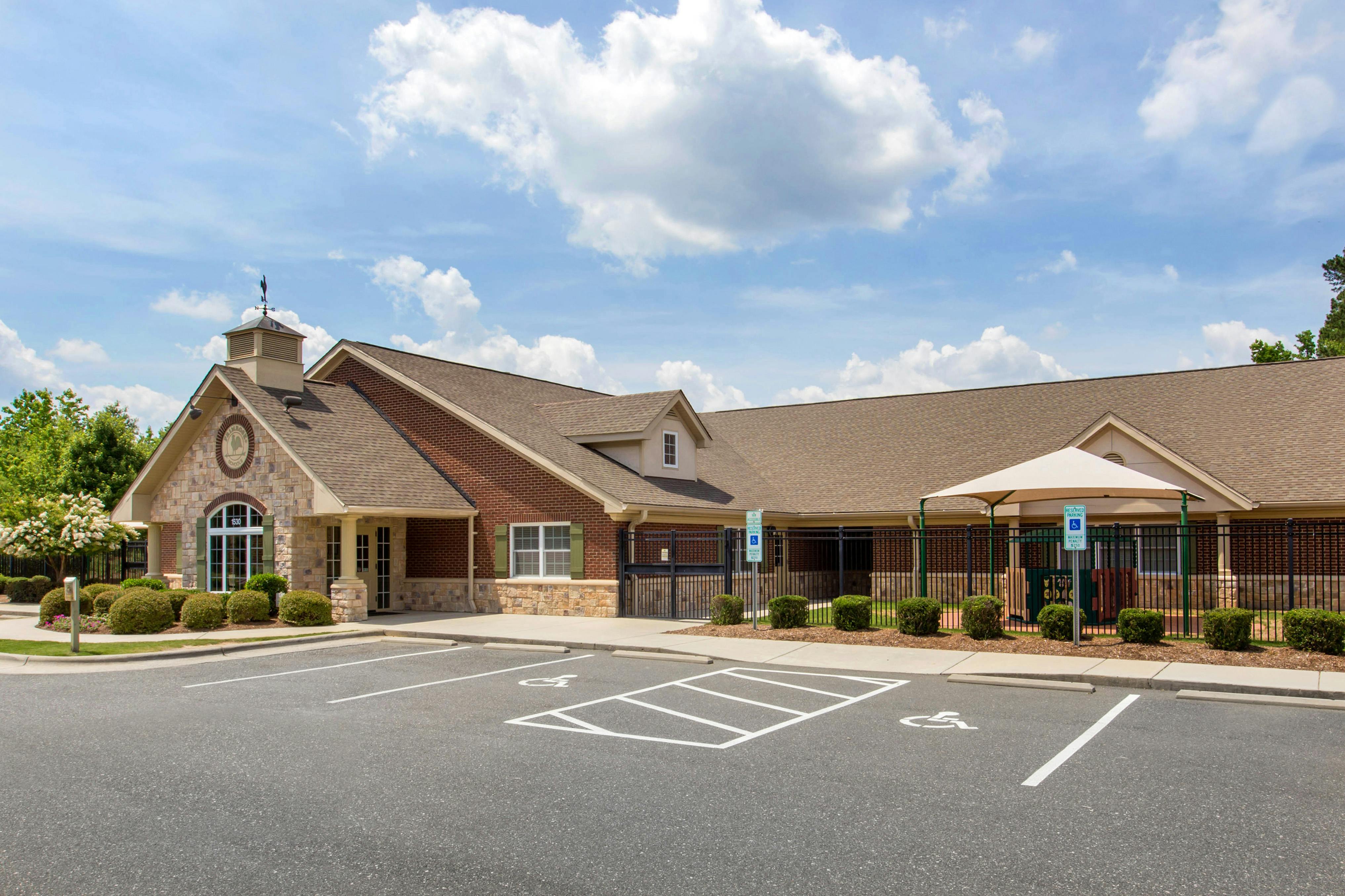 Exterior of a single-story brick and stone building with a parking lot in front
