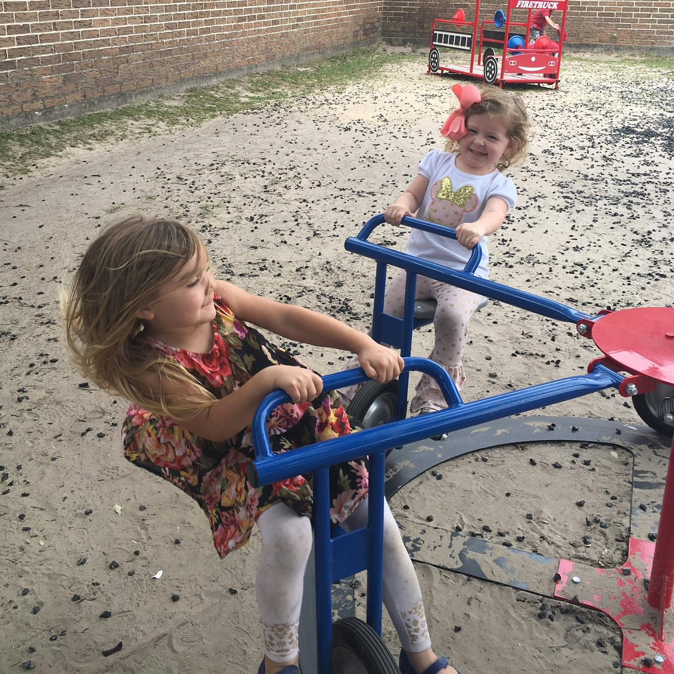 Two children on a playground riding a seesaw