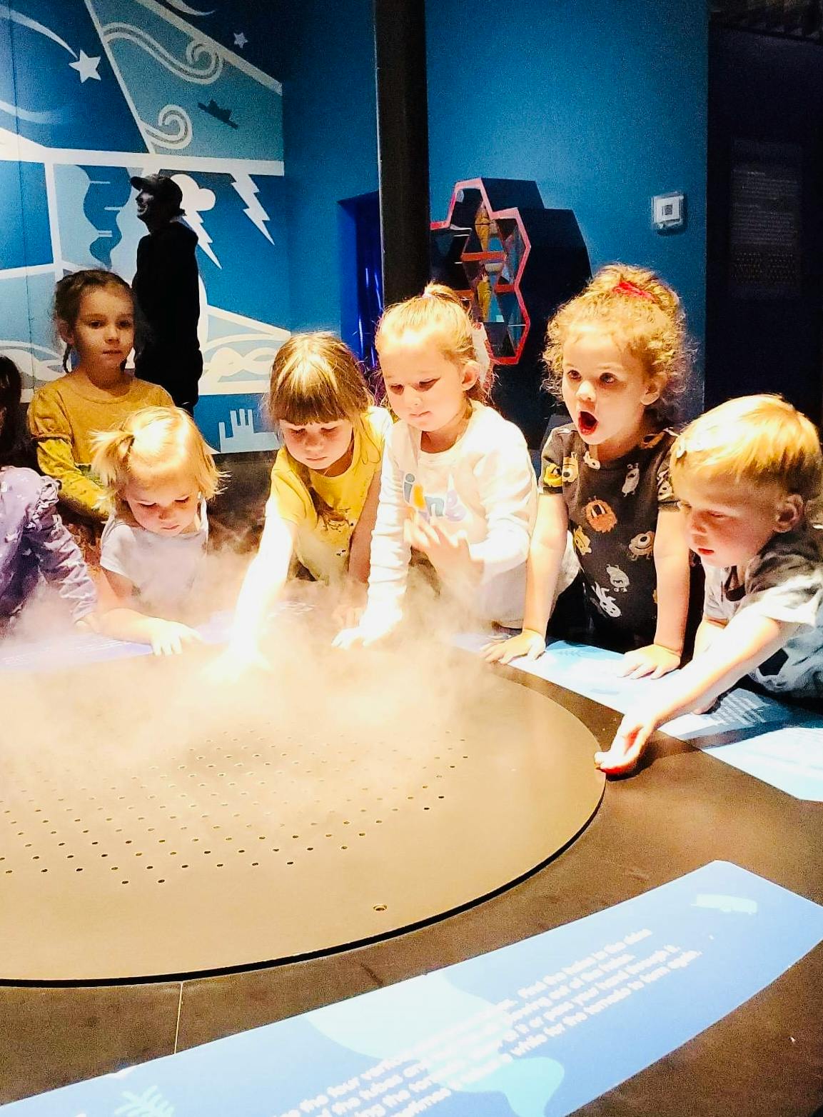 Children gathered around a table with mist rising from it