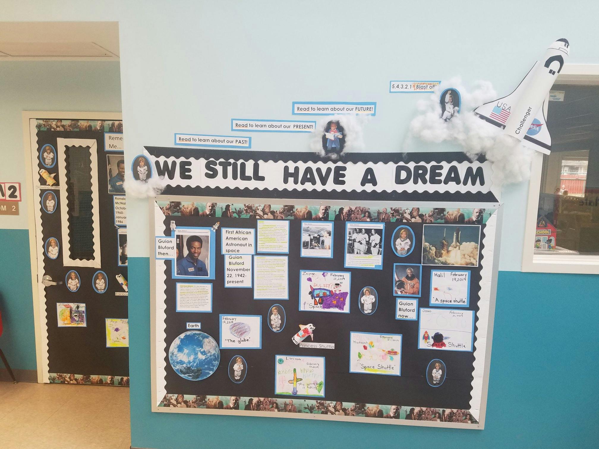 Bulletin board with "WE STILL HAVE A DREAM" and various photos and papers
