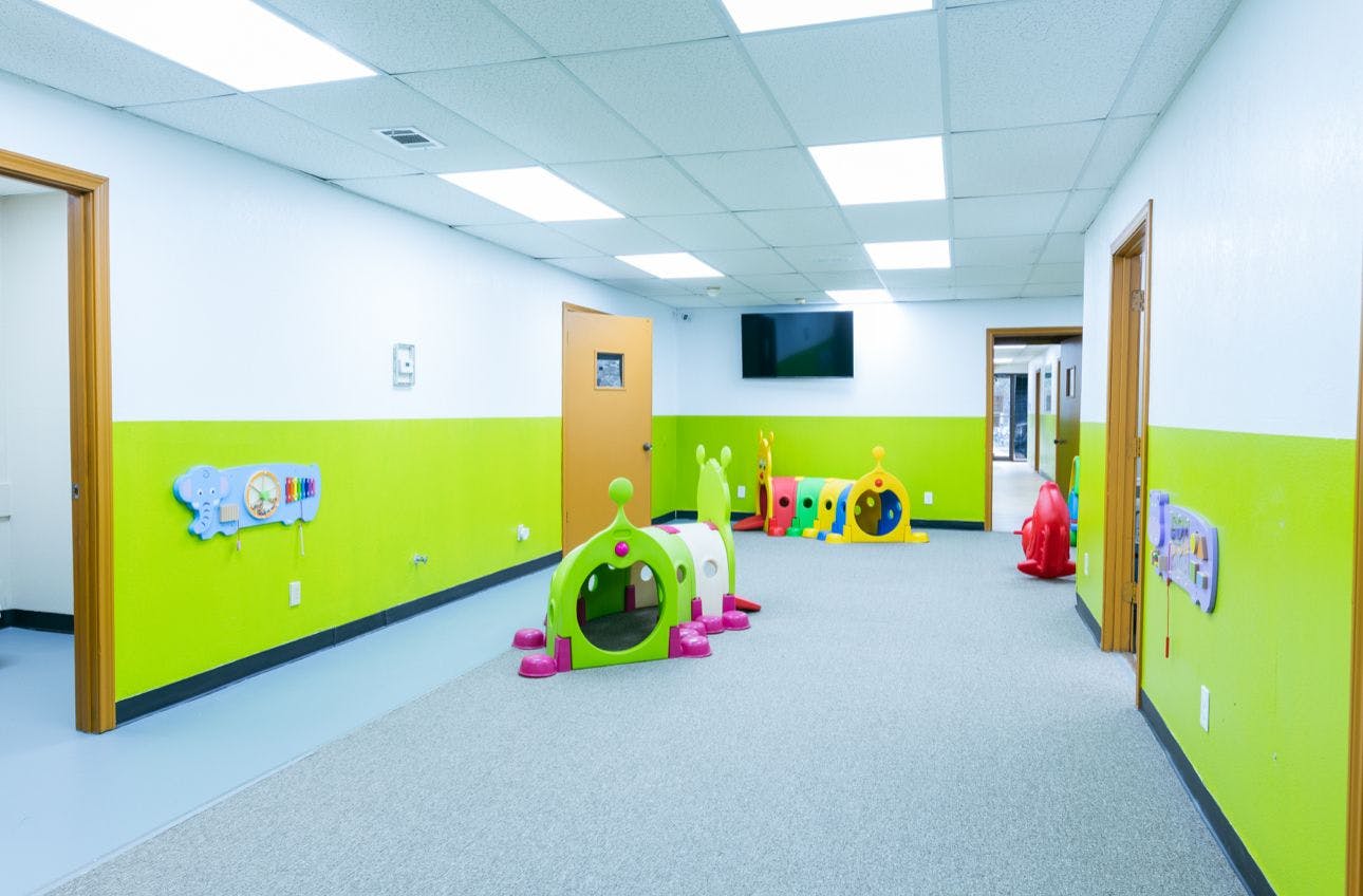 Playroom with plastic tunnels and wall-mounted activity toys