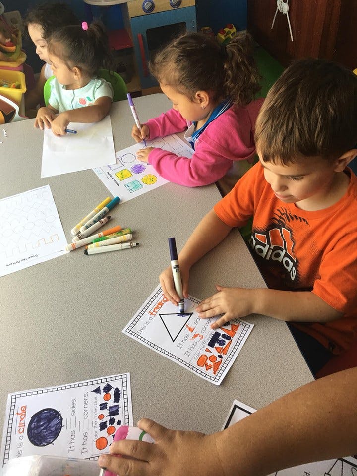Children coloring at a table in a classroom