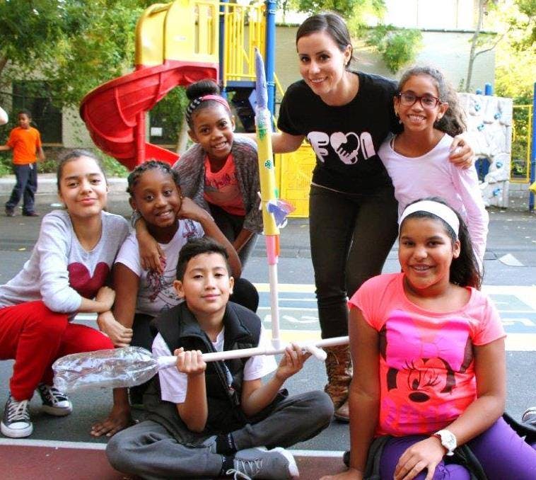 Adult and children posing with a craft rocket and broom
