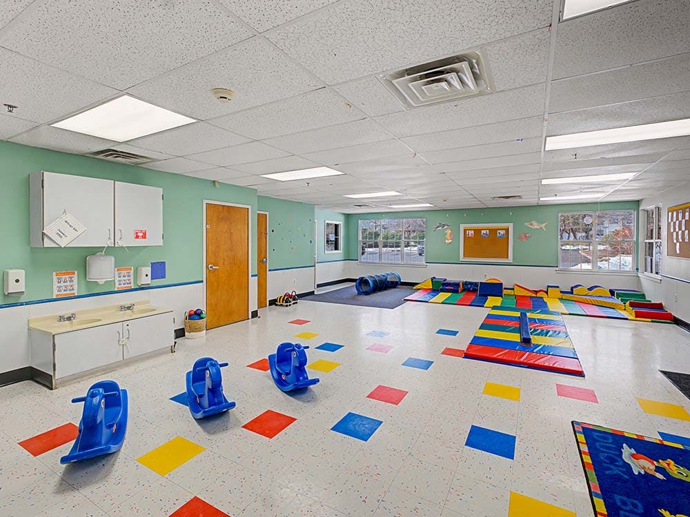 Playroom with blue rocking horses and colorful mats