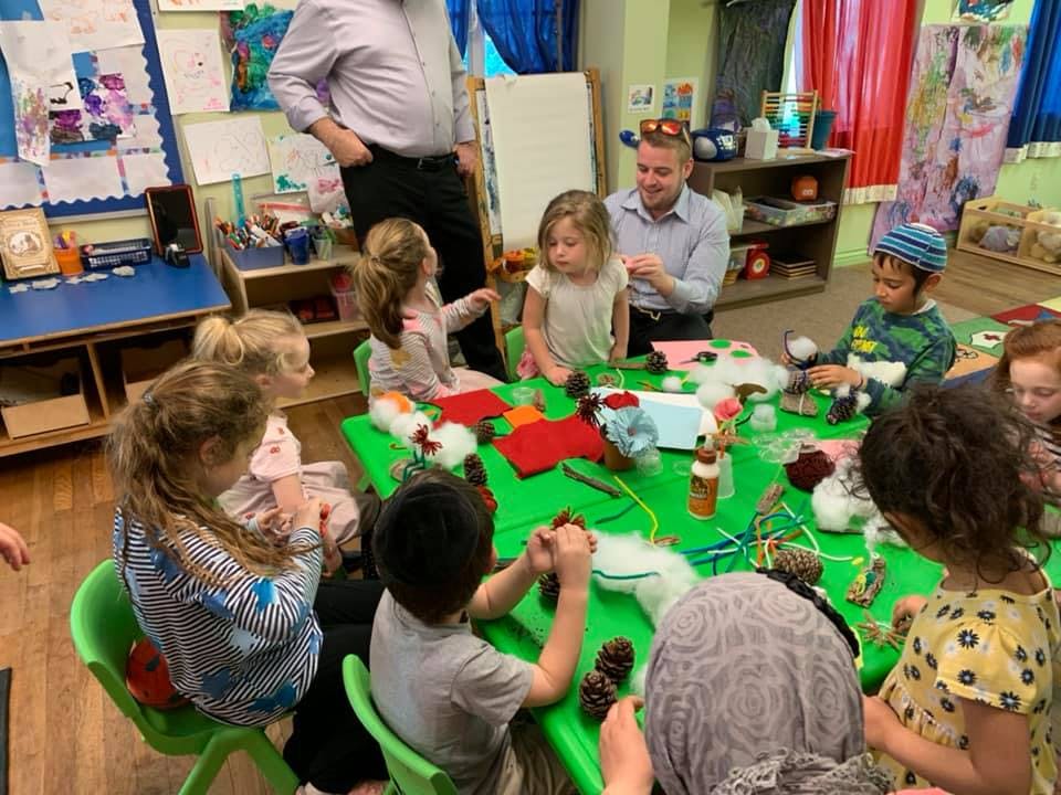 Adults and children gathered around a table doing crafts
