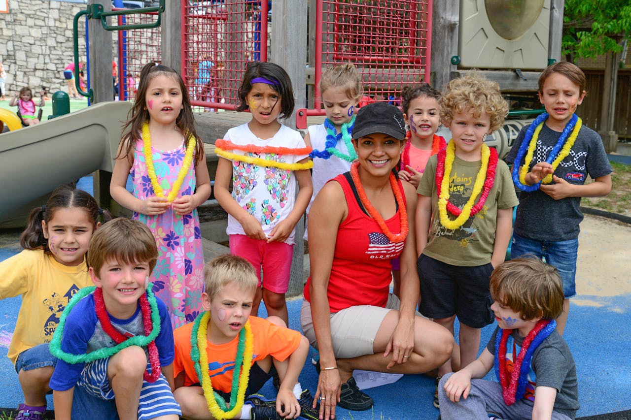 Adult and children wearing leis on a playground