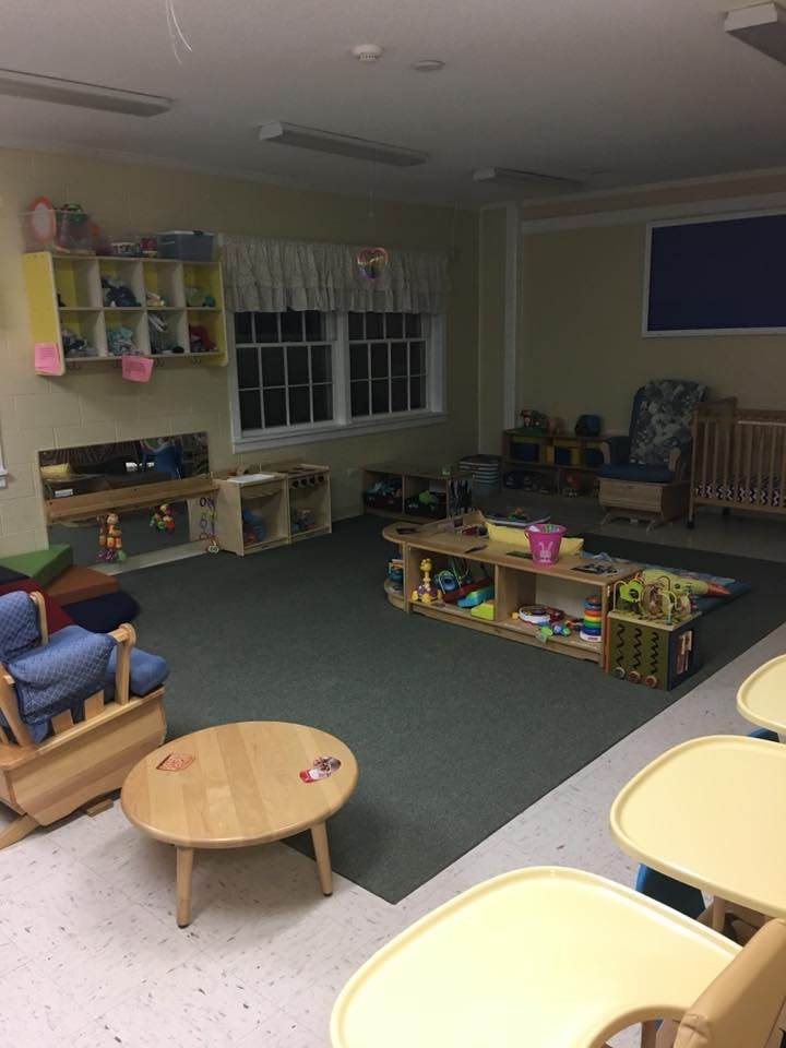 A classroom with various toys, furniture, and a crib