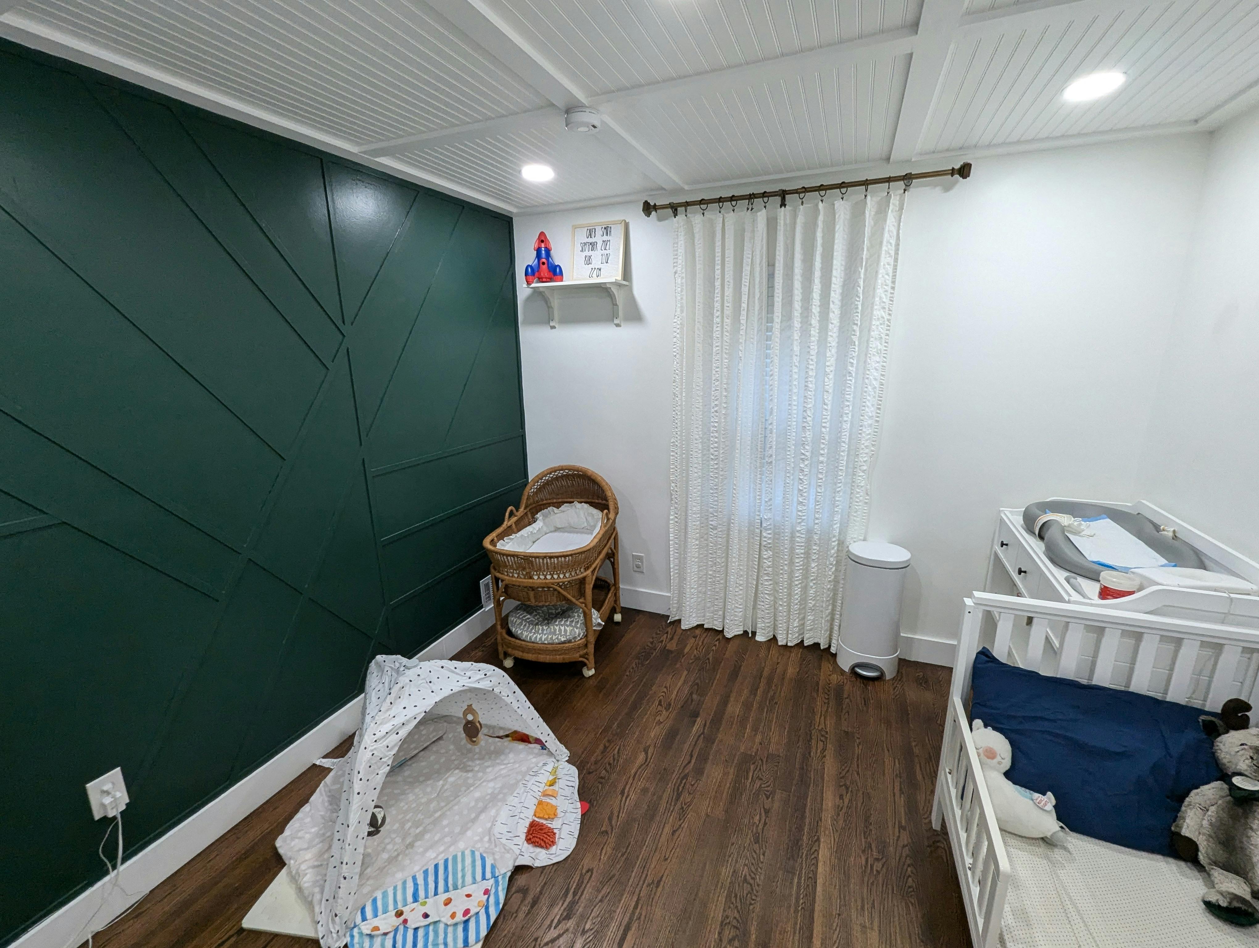 Nursery room with two cribs, a bassinet, and a playpen