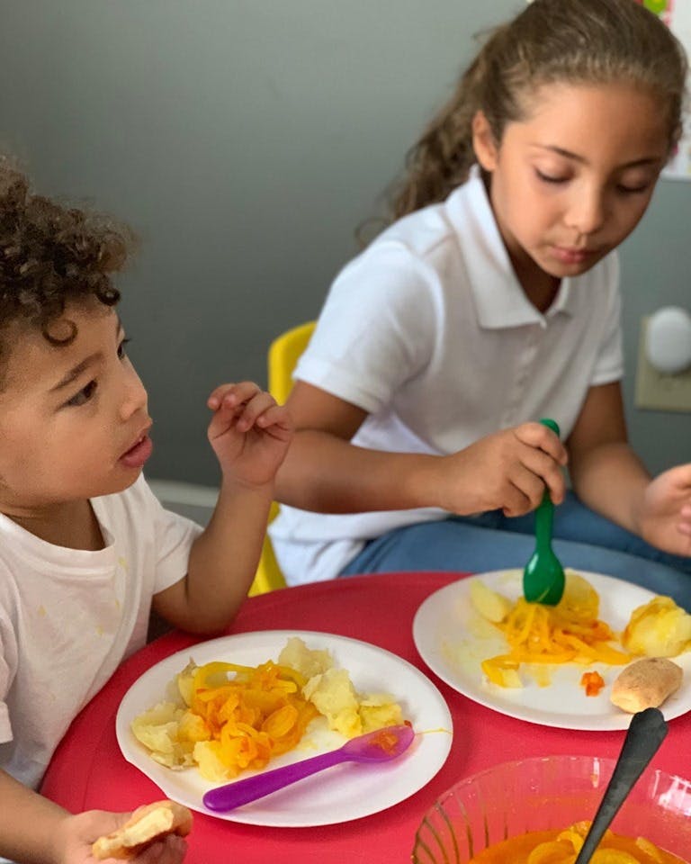 Two children eating food at a table