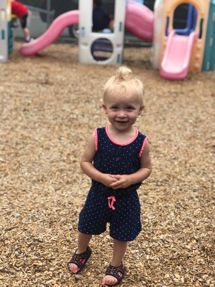 Child standing on wood chips at a playground