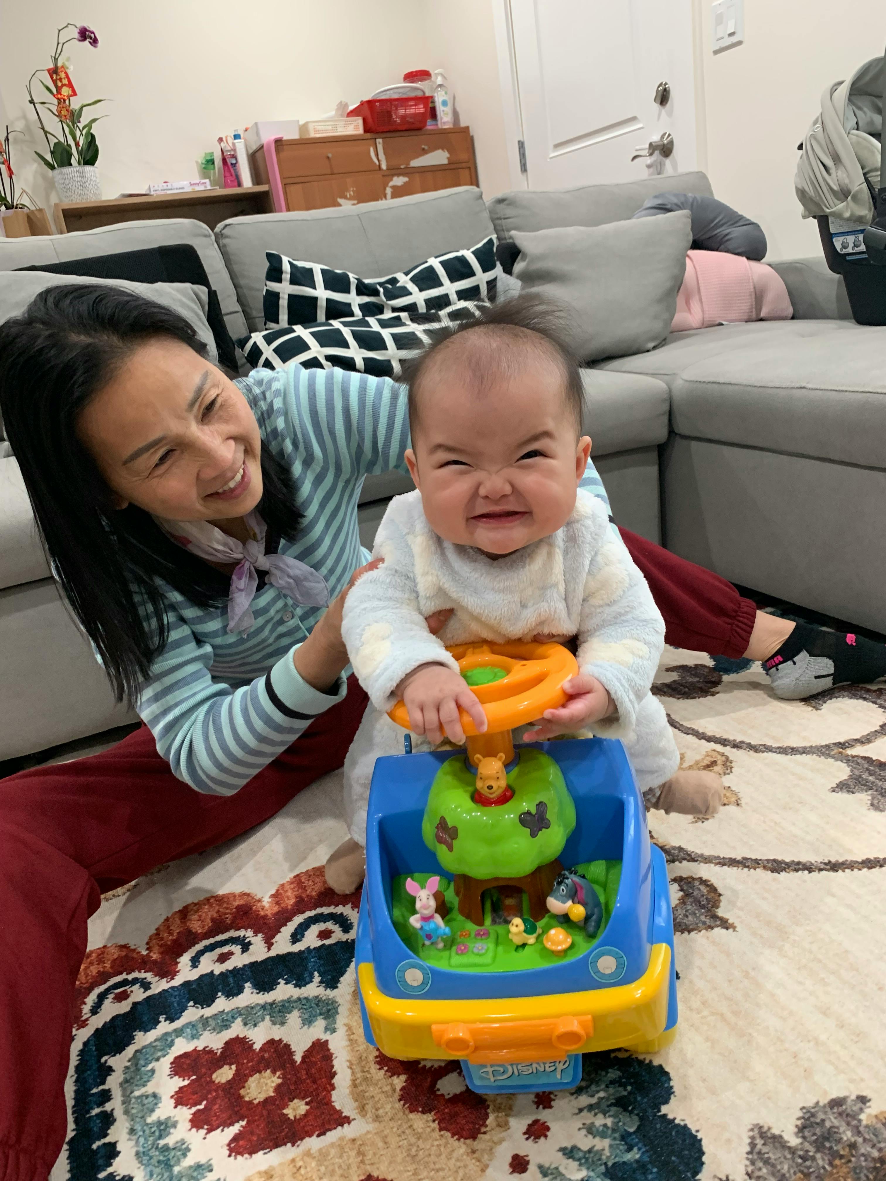 Person and child playing with a toy car