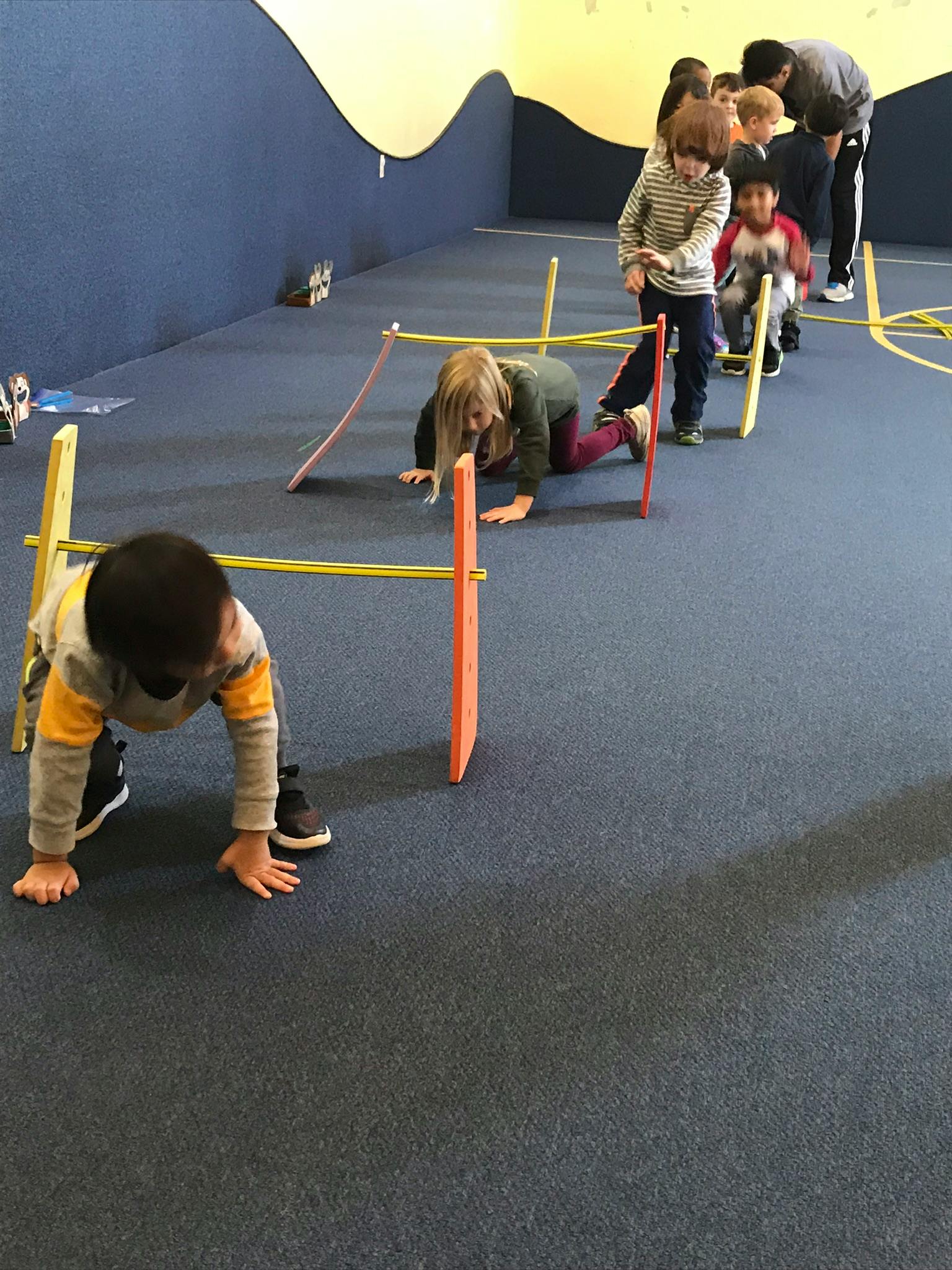 Children crawling and stepping through an obstacle course