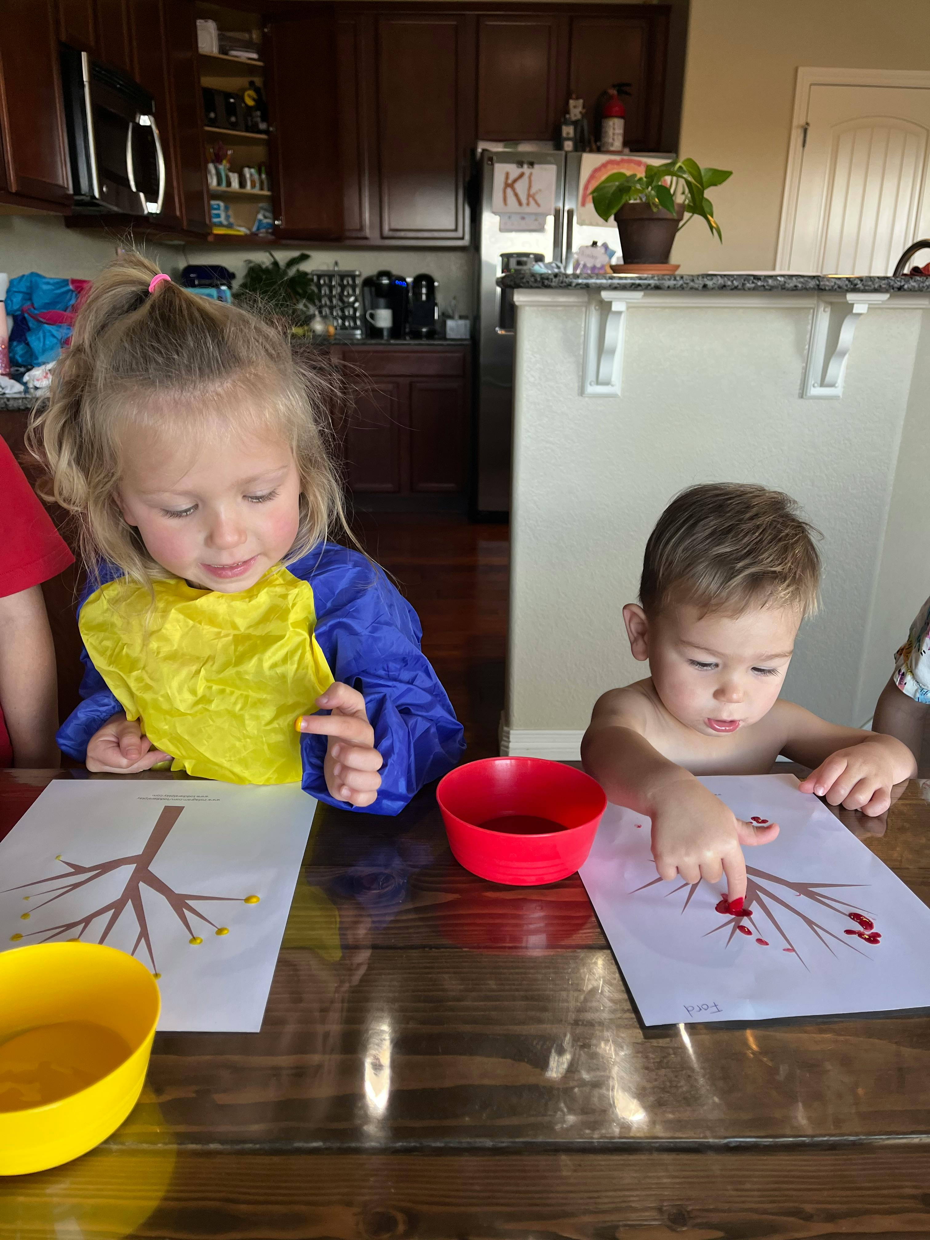 Two children painting at a table