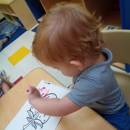 Child coloring a picture at a desk