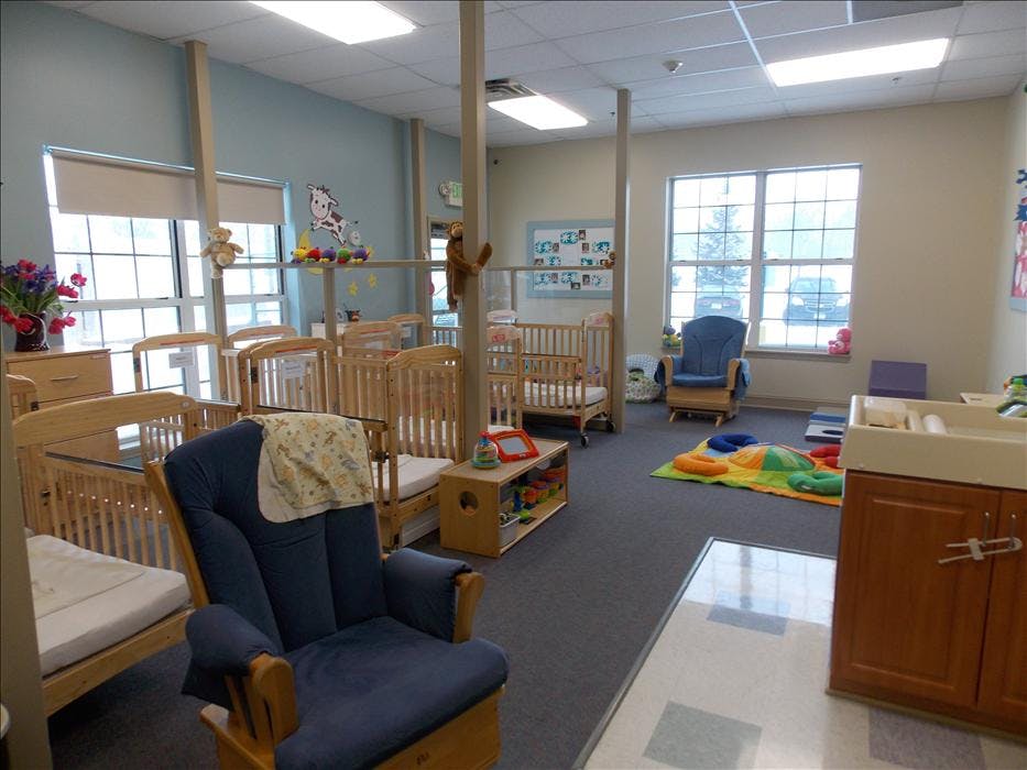 Baby room with multiple cribs, rockers, and play mats