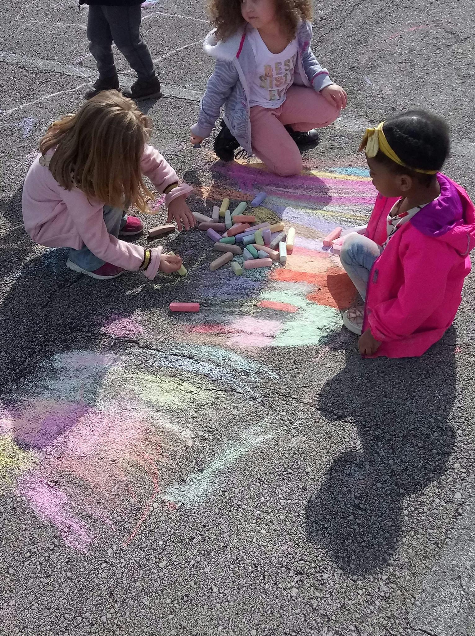 Children drawing with chalk on pavement