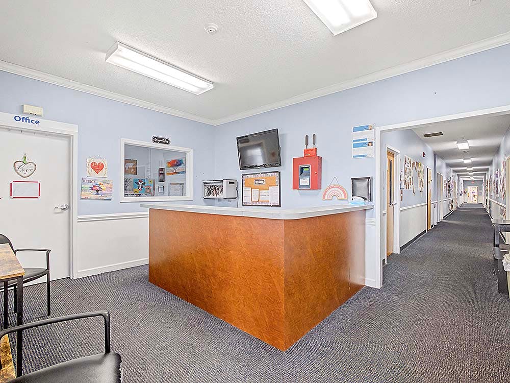 Reception desk with office window and a hallway extending into the distance