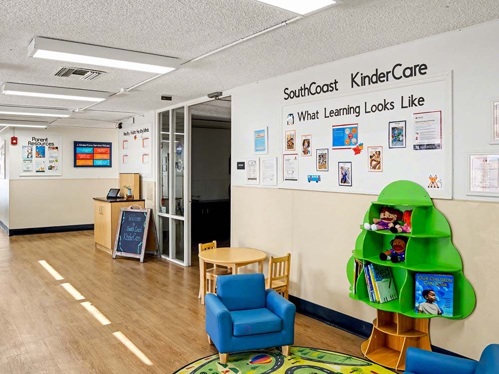 lobby of a daycare with a chalkboard sign and play area