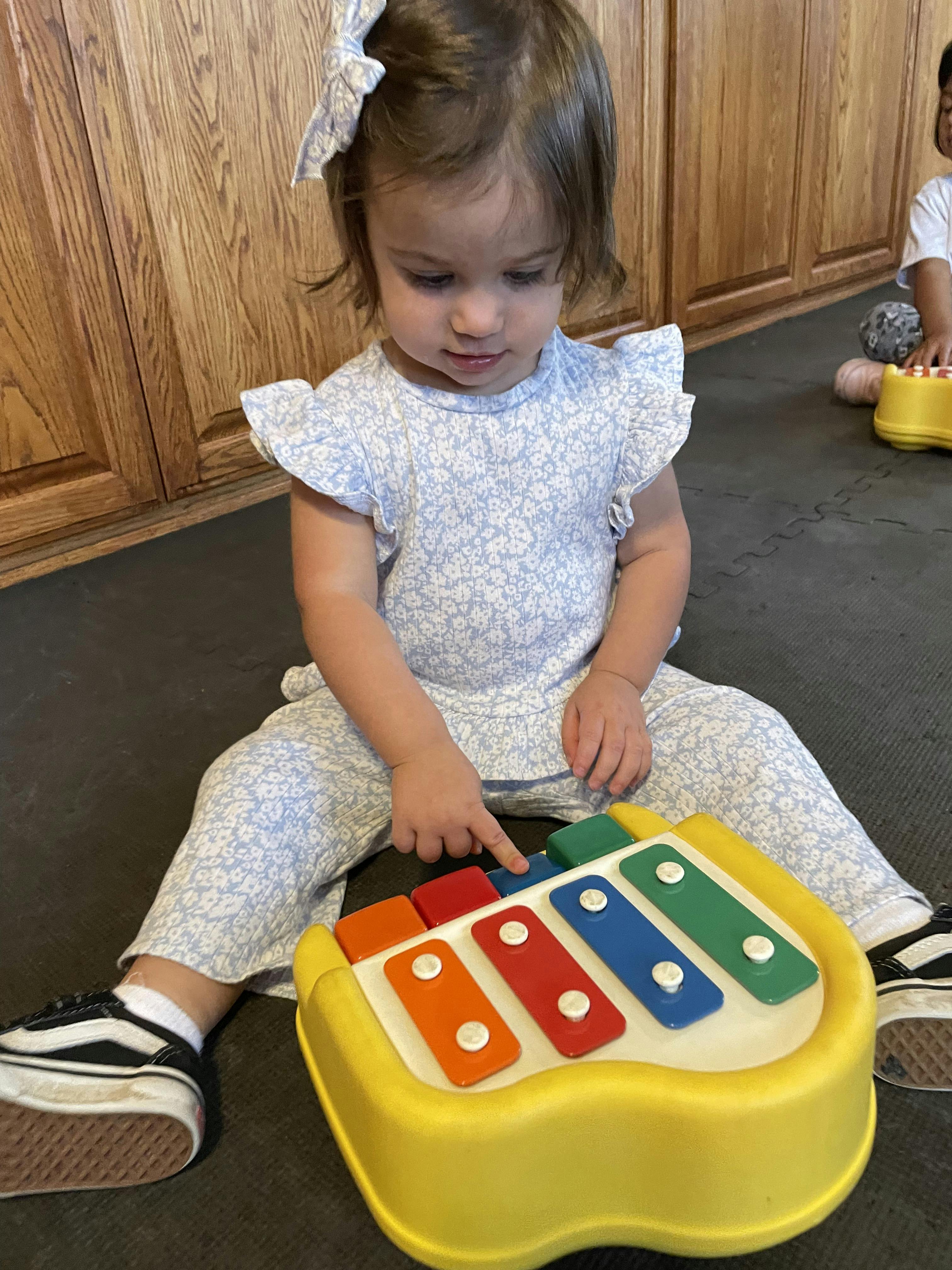 Child playing with a colorful toy xylophone