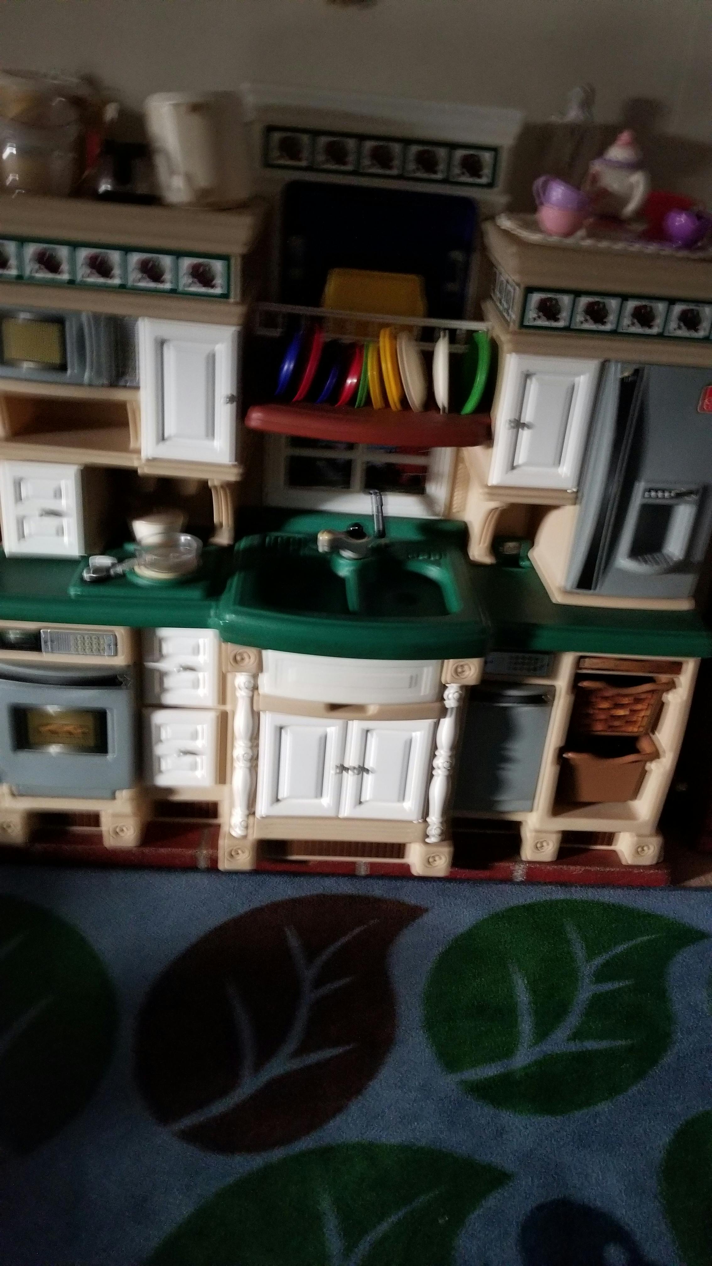 Toy kitchen set with green countertops and white cabinets