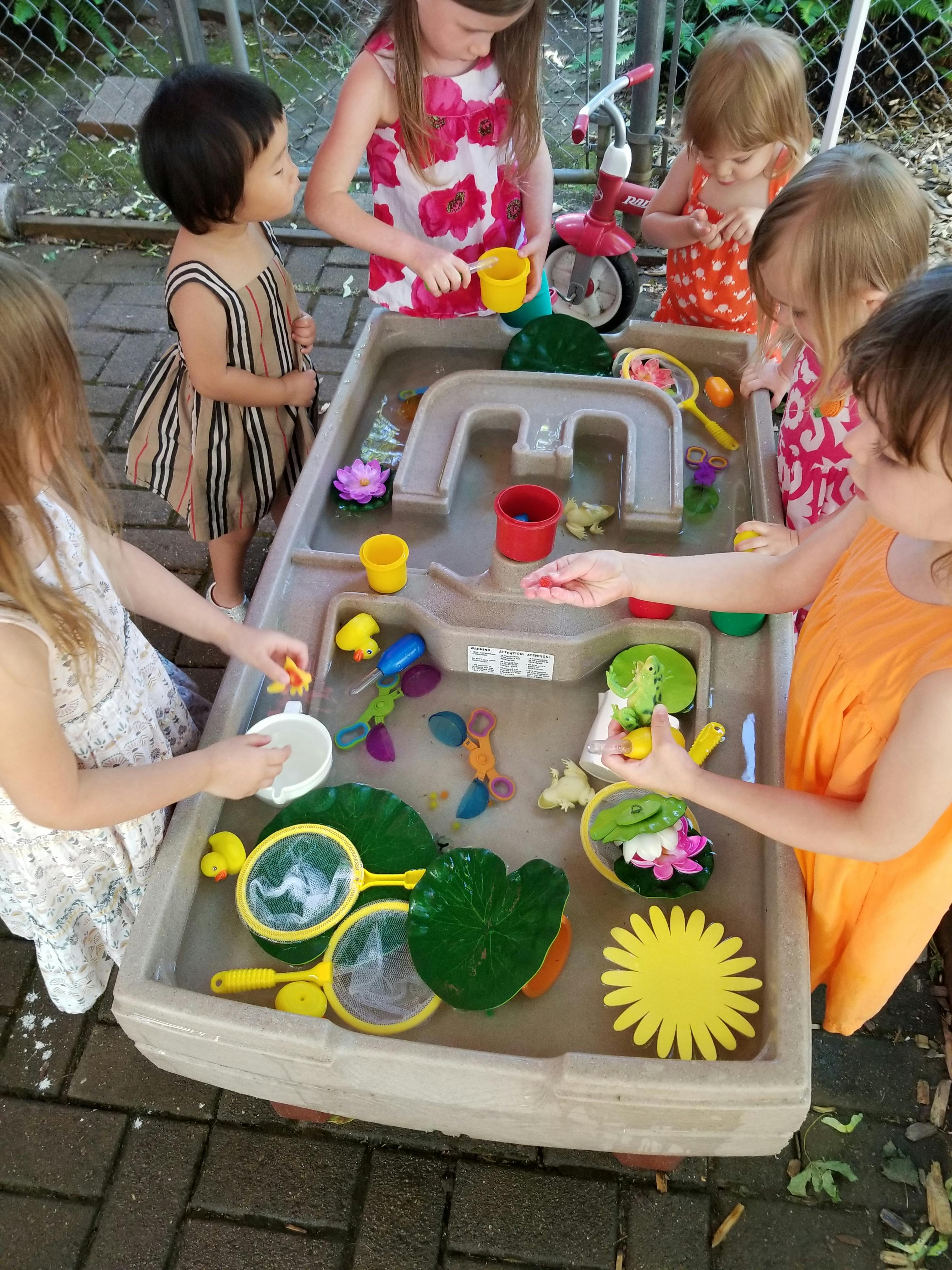 Children playing with a water table outdoors