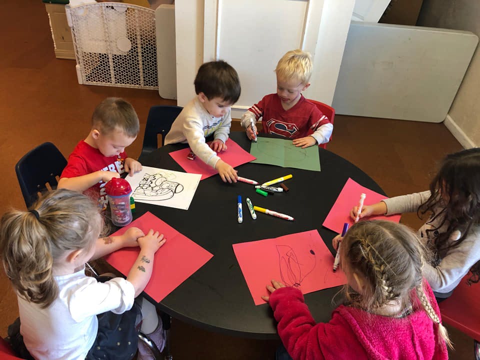 Children drawing and coloring at a table