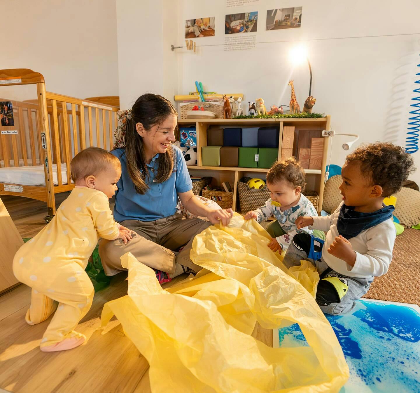 Person playing with three children in a room