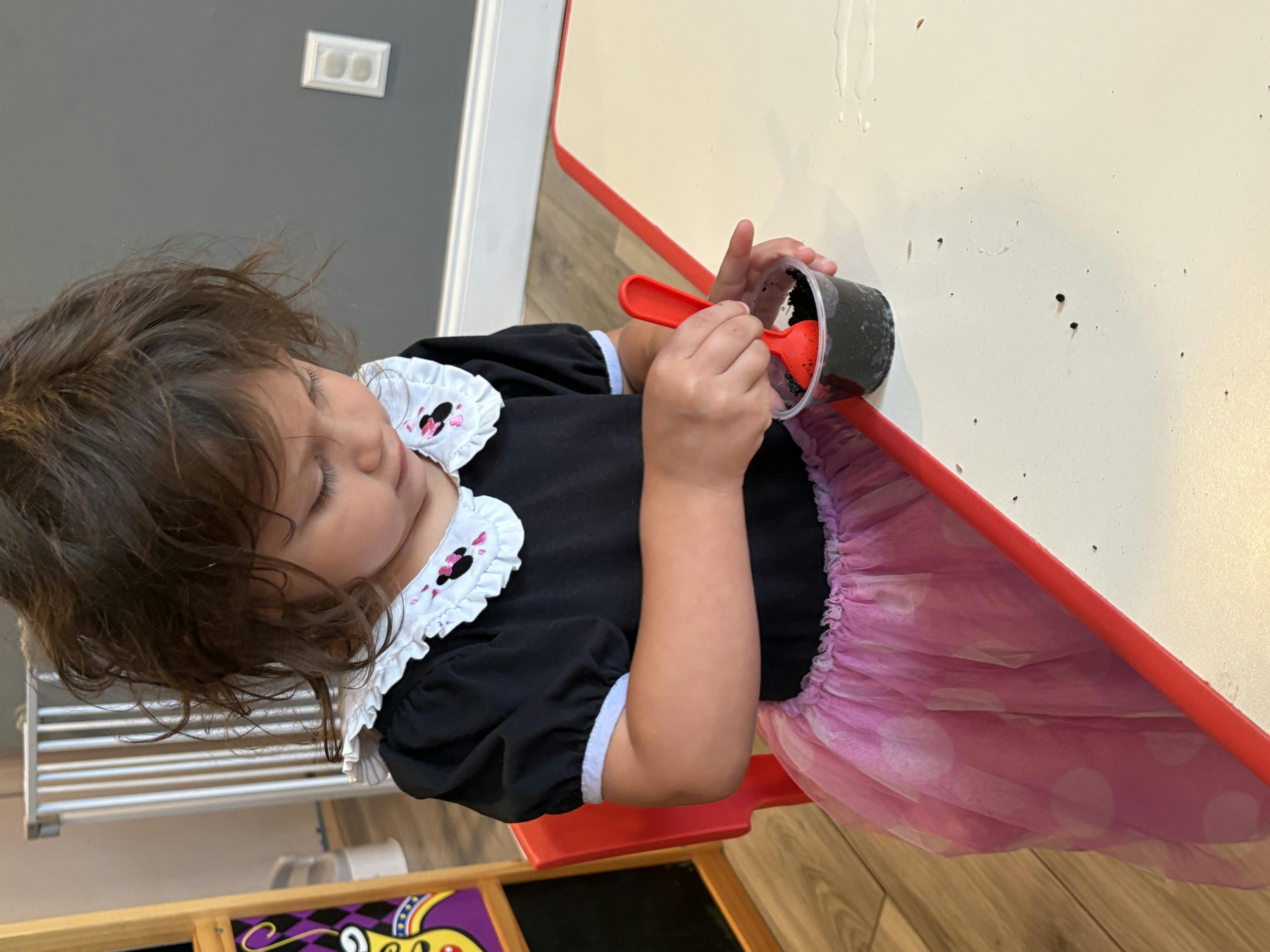 Child playing with a cup and spoon