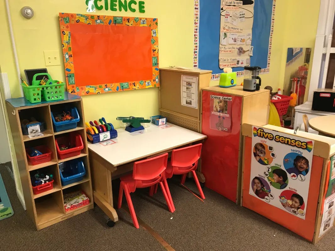 Classroom with small table and chairs, storage shelves, and wall decorations
