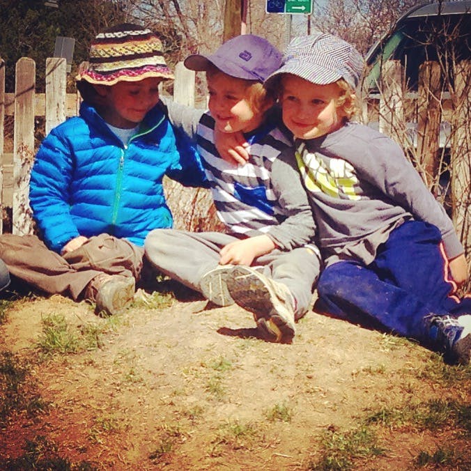 Three children sitting together outdoors