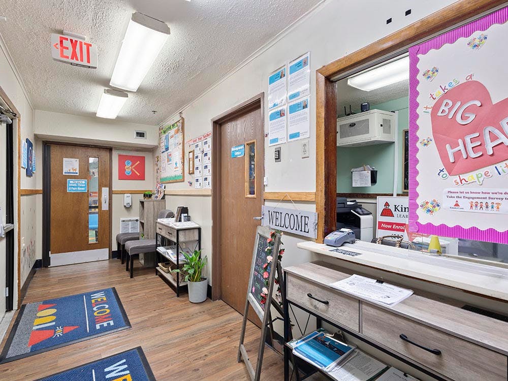 Hallway with an exit sign, two doors, and a reception desk