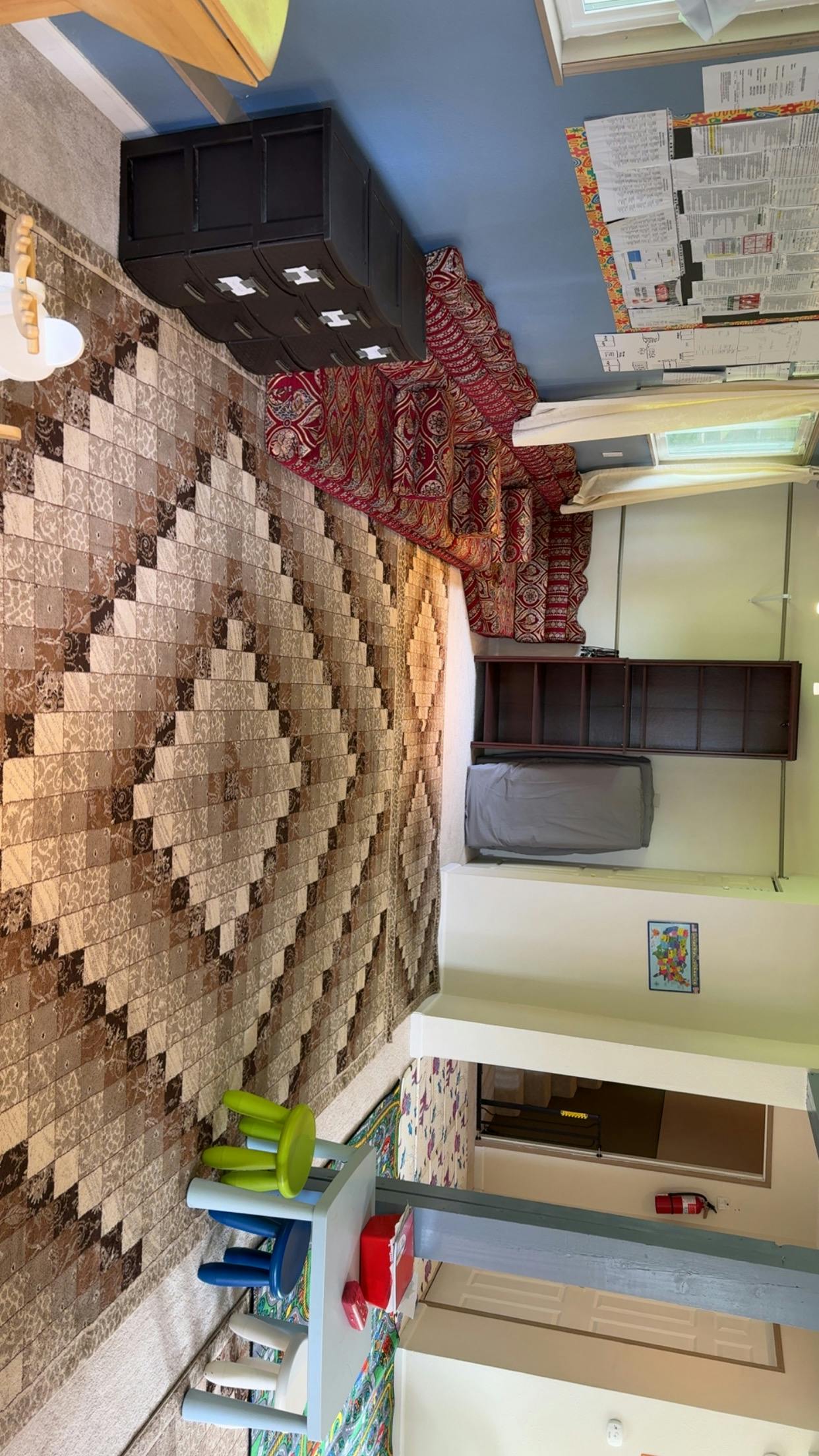 Room with patterned rug, dark wooden furniture, and small chairs