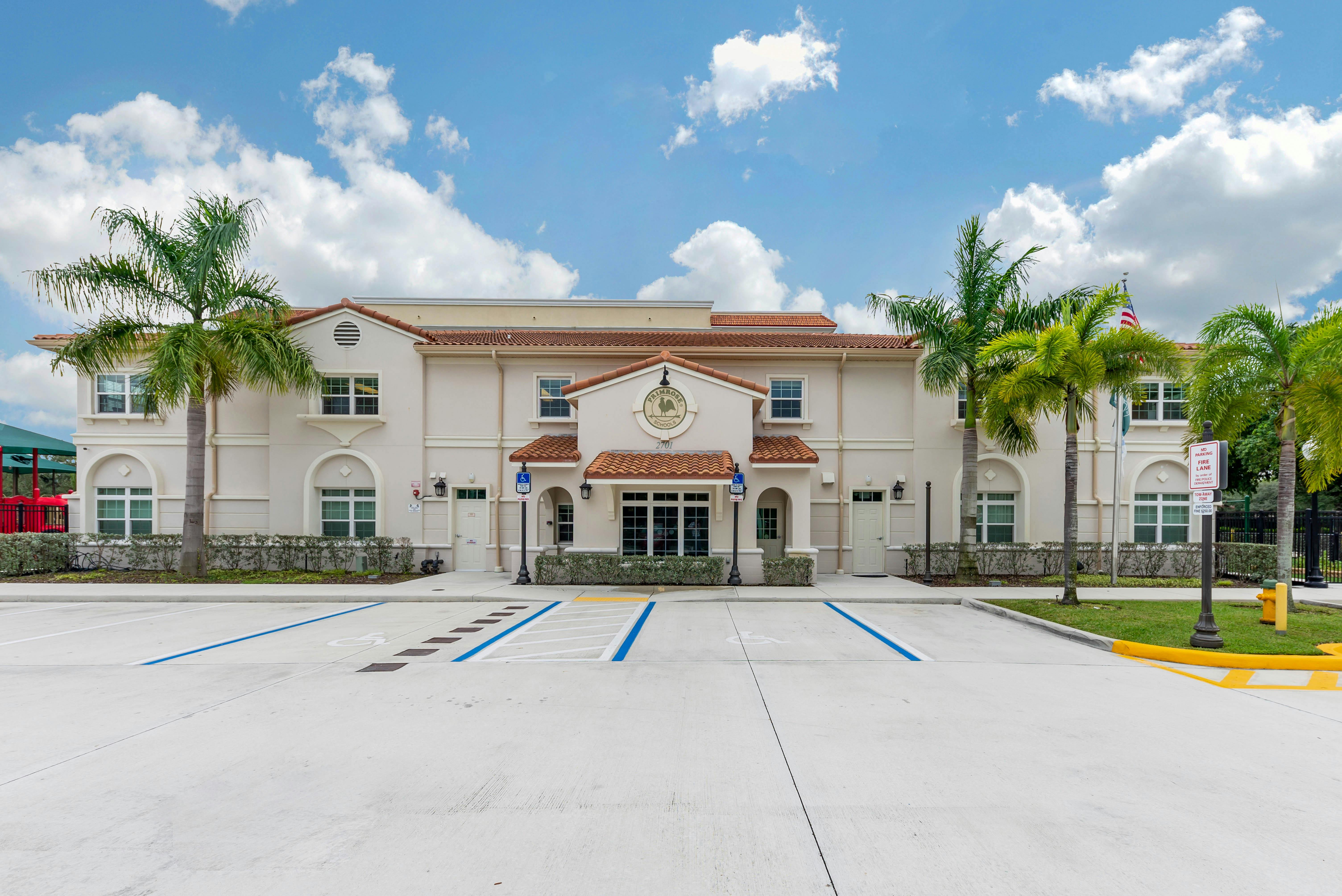 Front exterior of Primrose Schools building with palm trees and a parking lot