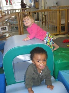 Two children playing on soft play equipment
