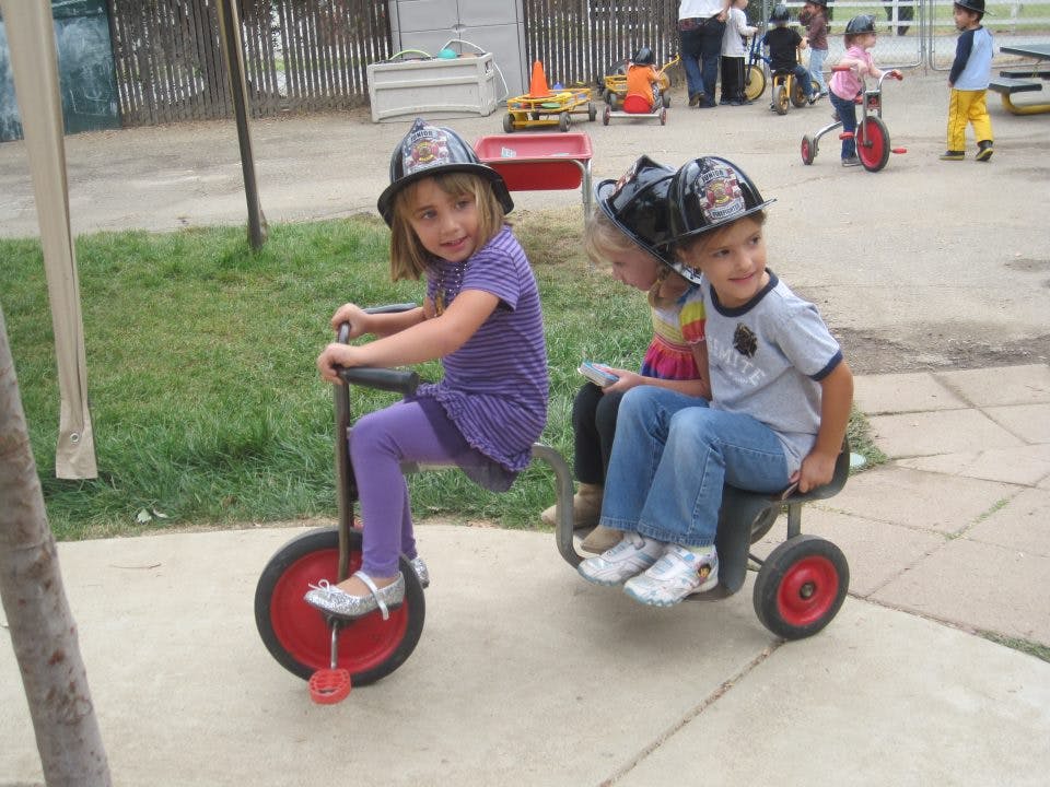 Children playing on riding toys outdoors