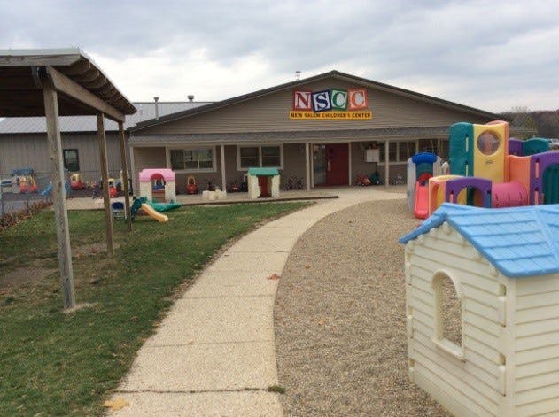 Building with "NSCC" sign and playground equipment outside