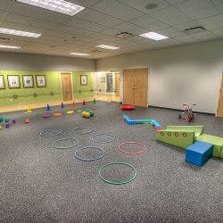 Playroom with hoops, cones, and blocks on the floor