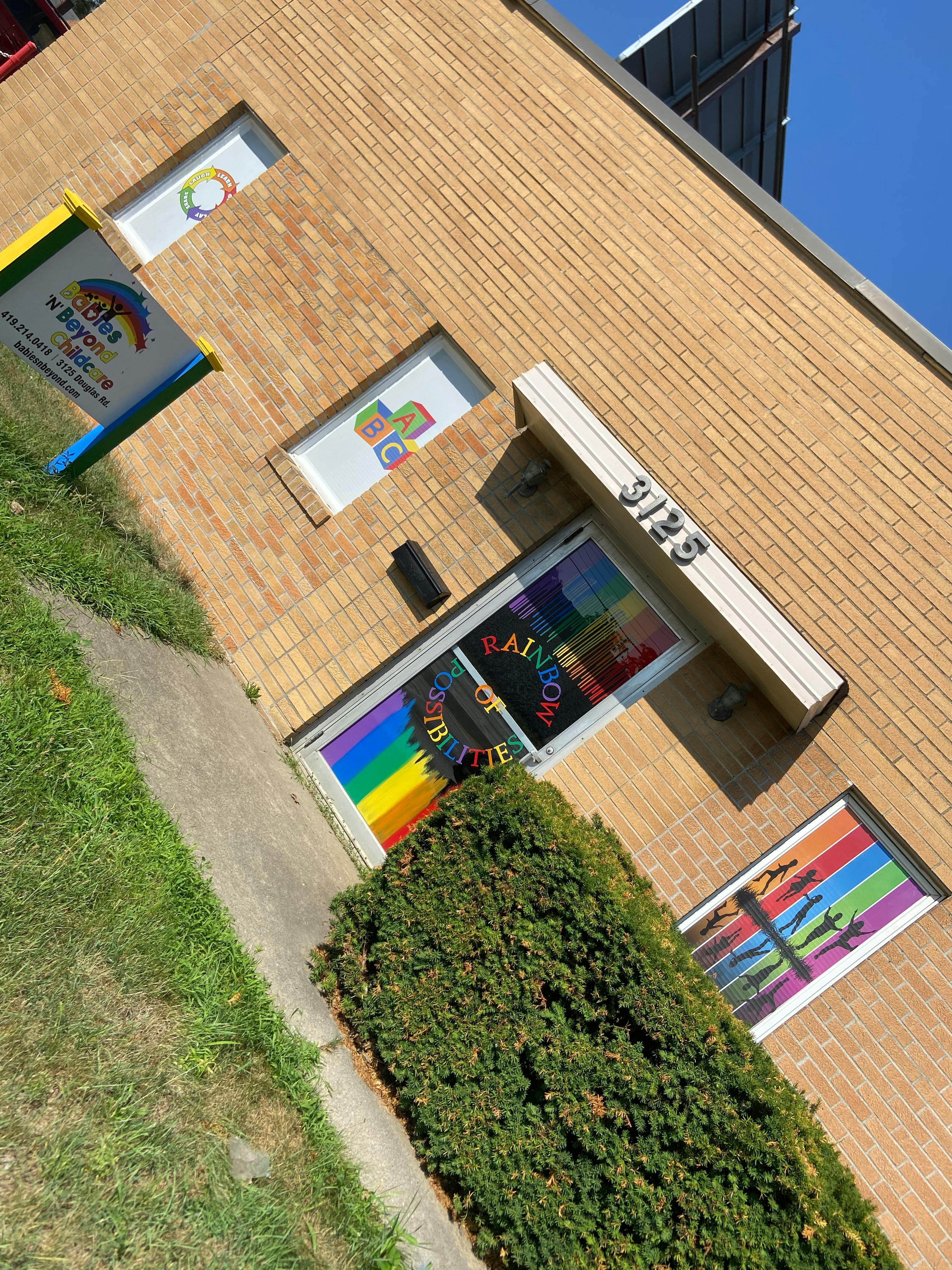 Brick building with a sign that says "Rainbow of Butterflies"