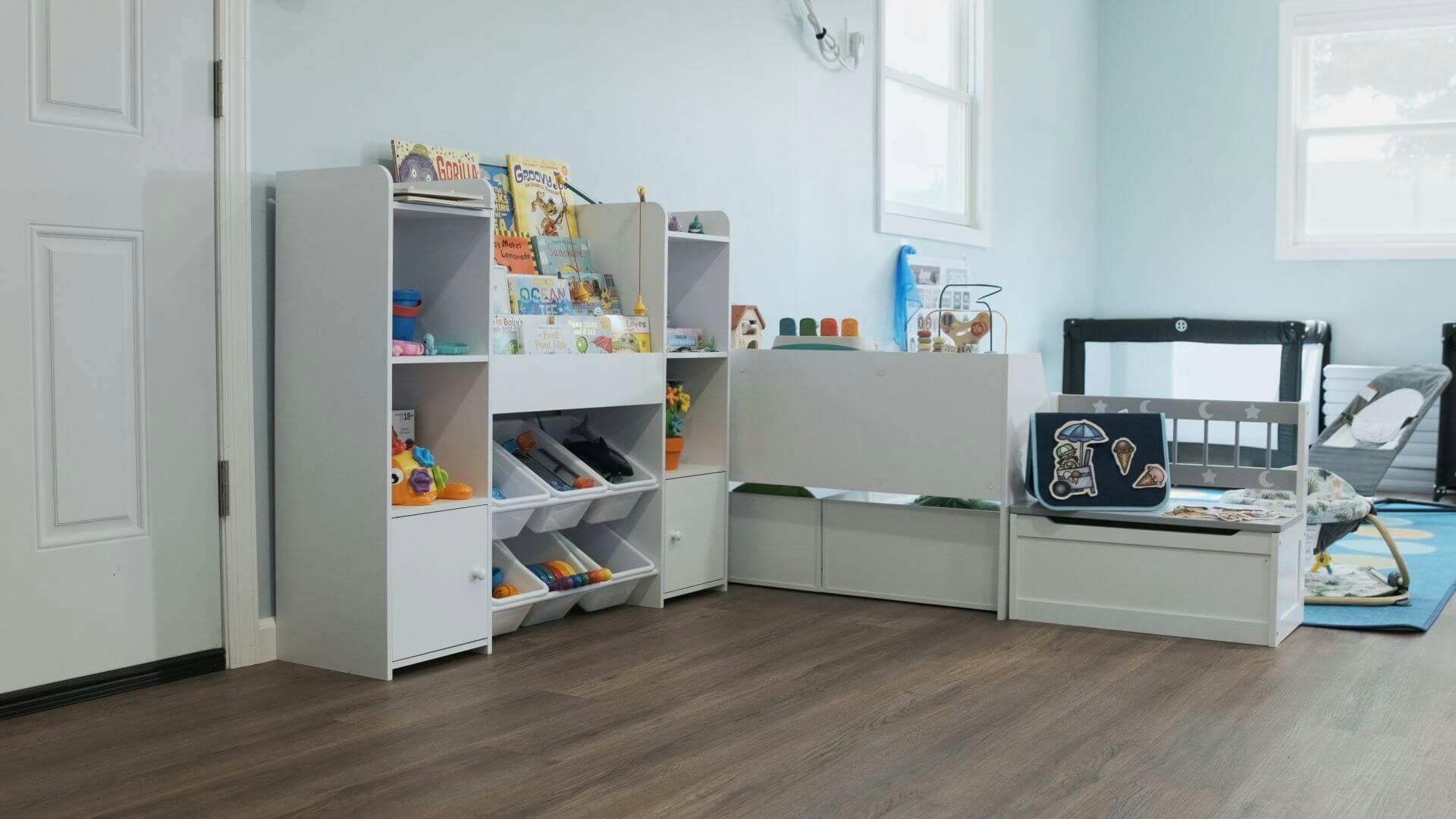 White storage shelving unit with children books and toys in a playroom