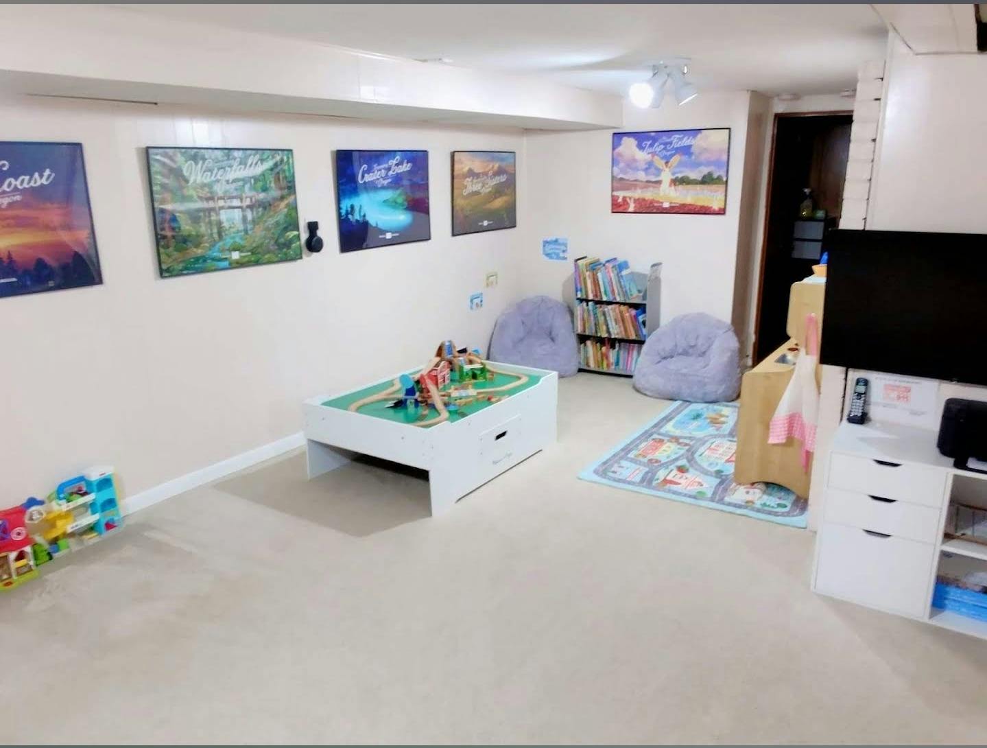 Playroom with a white play table, beanbag chairs, and bookshelves