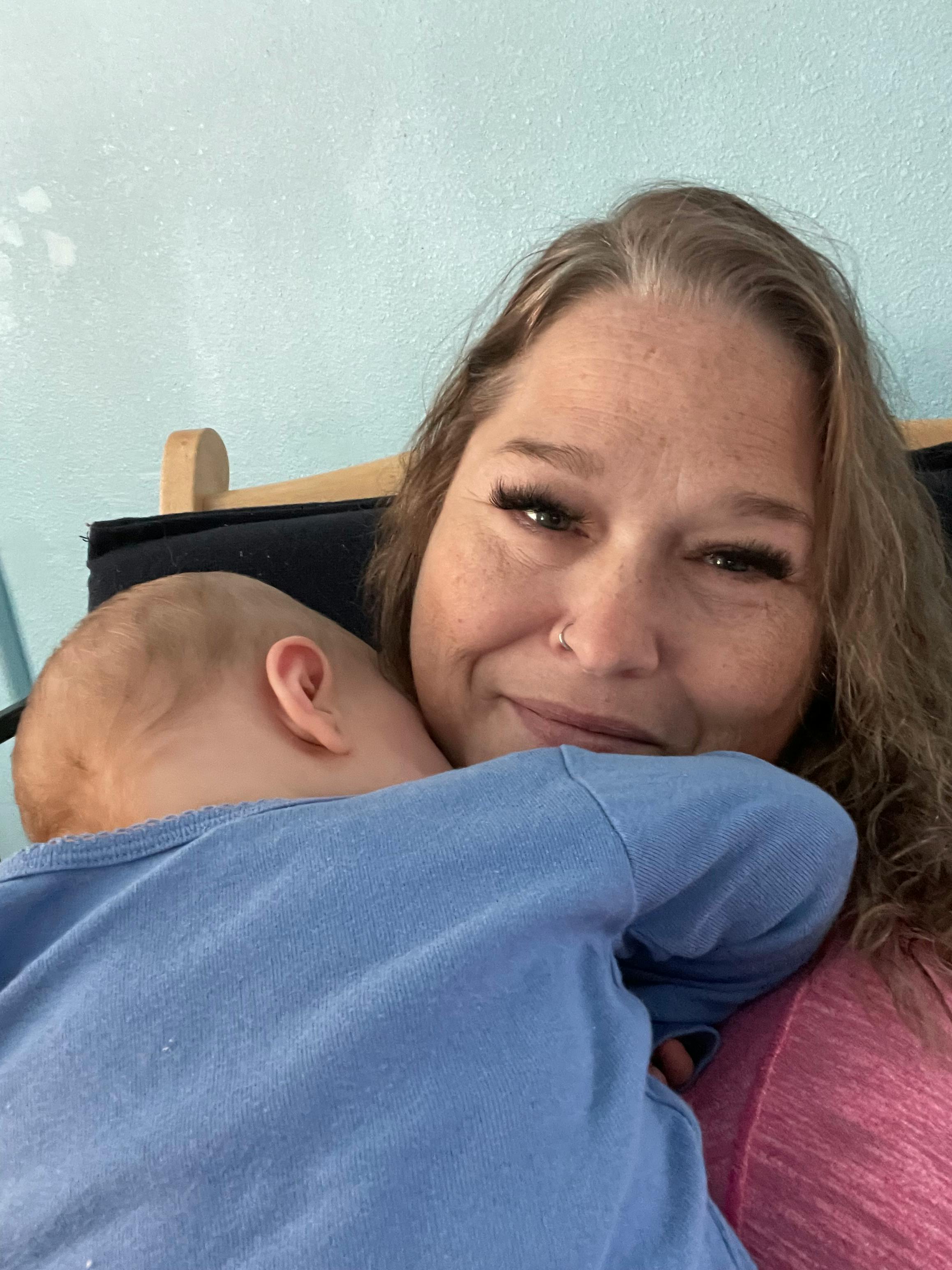 Person holding a child wearing a blue shirt