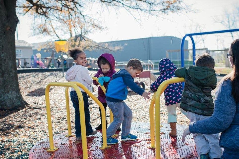 Children playing on a merry-go-round at a playground