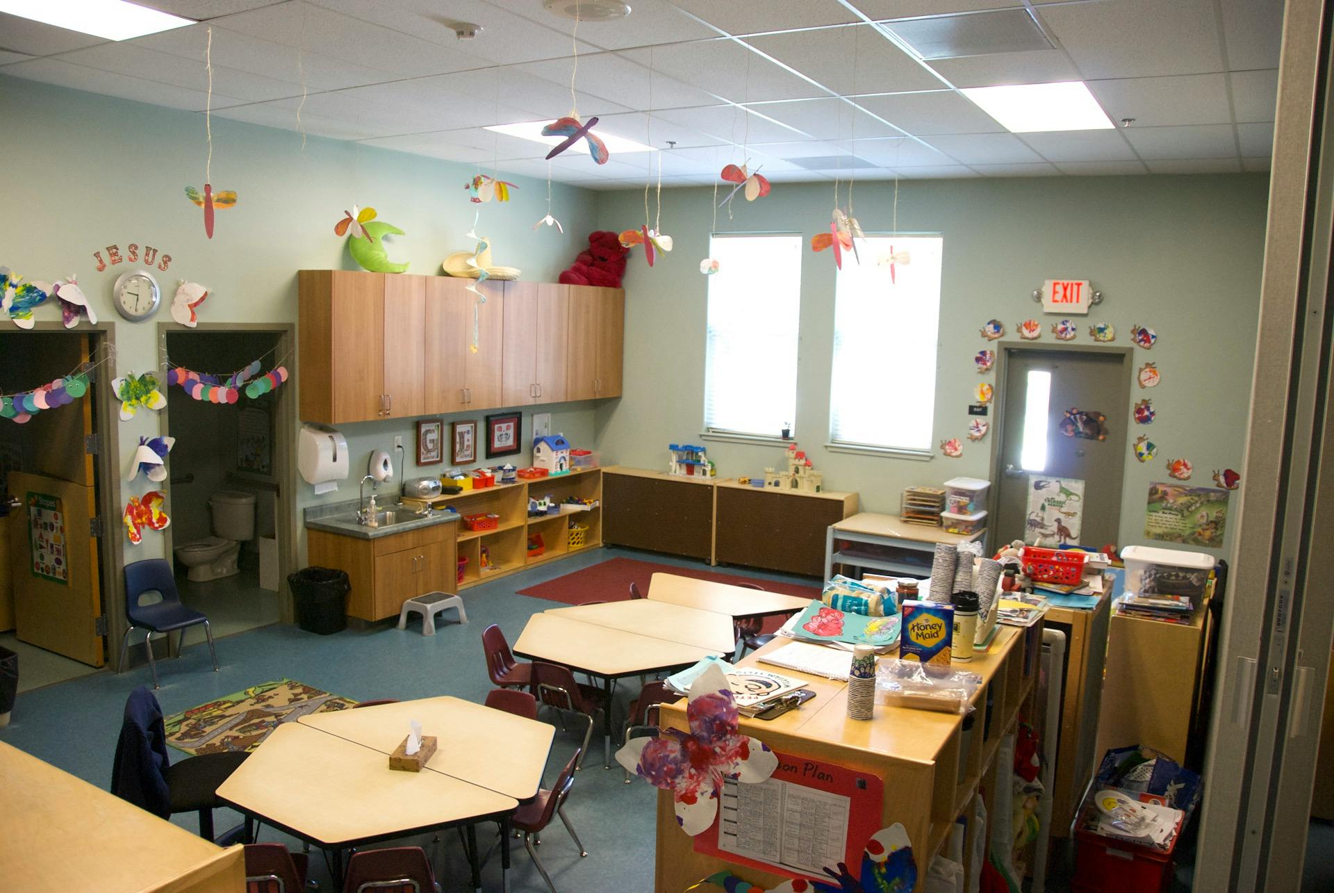 Classroom with tables, chairs, and storage cabinets