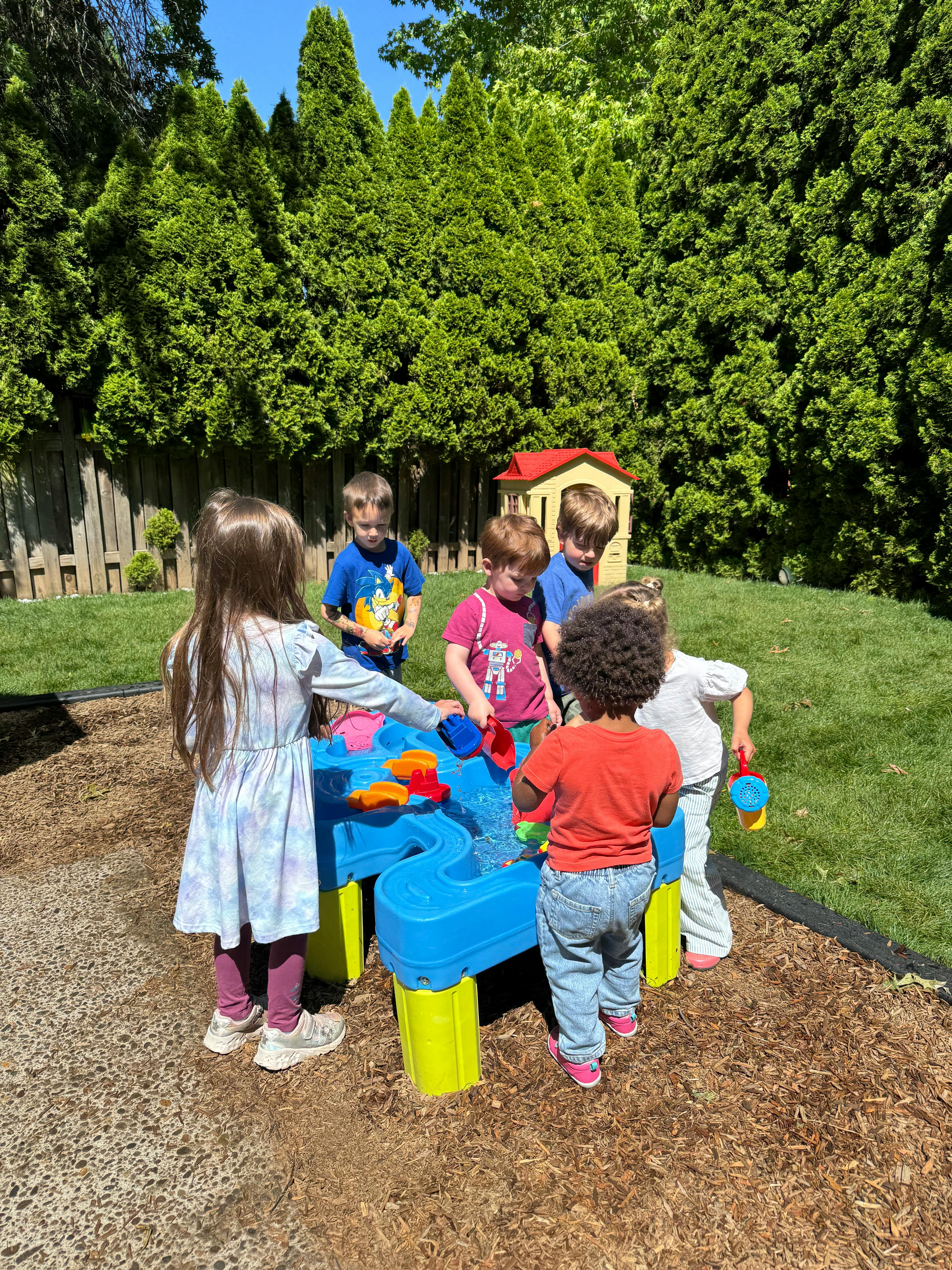 Children playing at a water table outdoors