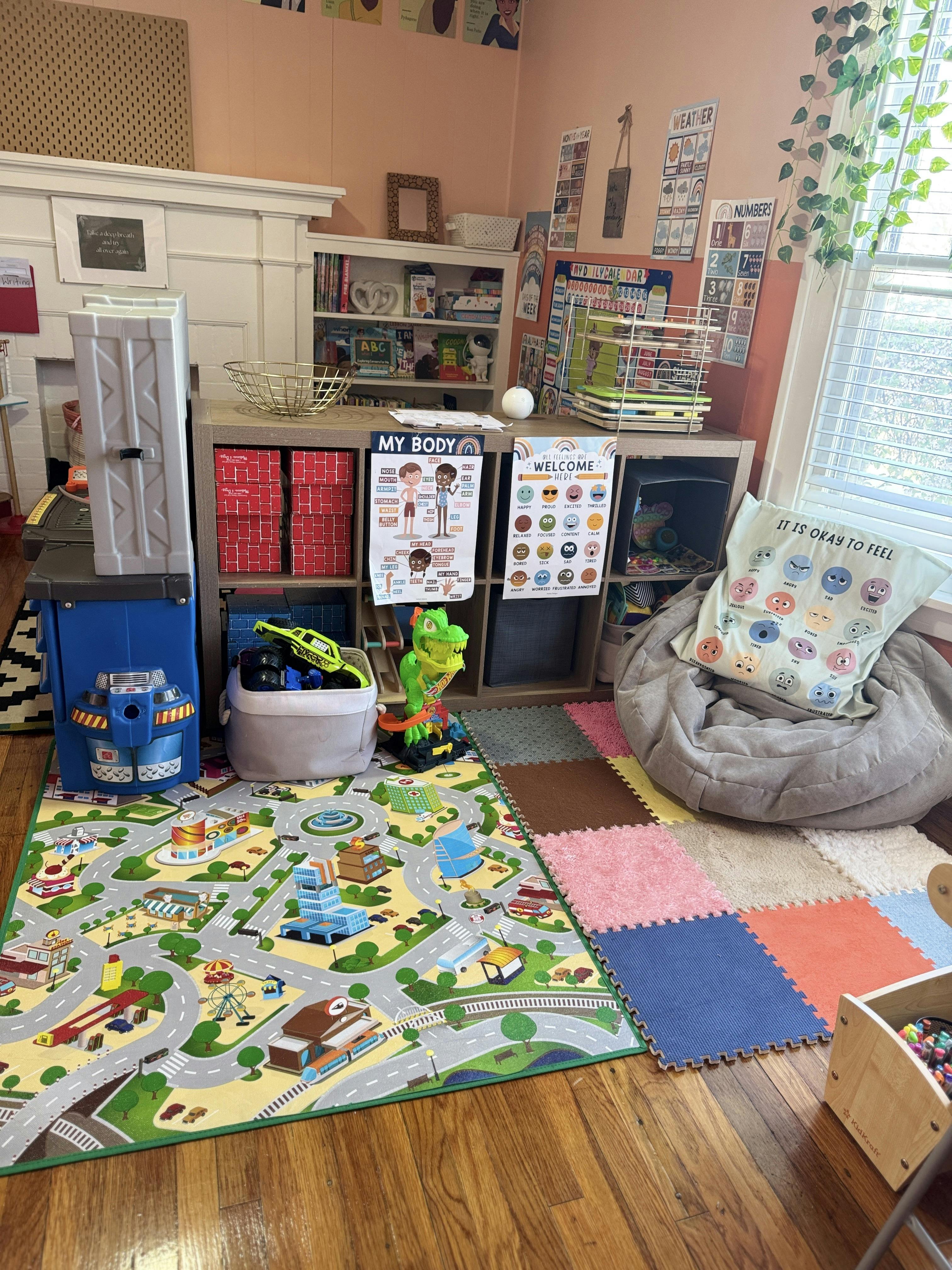 Playroom with a road map rug, a gray beanbag chair, and educational posters on the wall