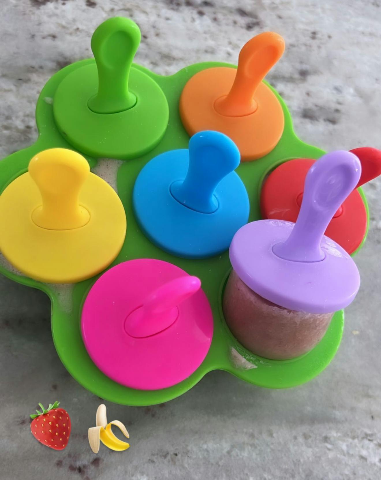 Colorful popsicle molds in a green tray, flower-shaped tray