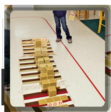 Child standing near a rug with wooden blocks arranged on it