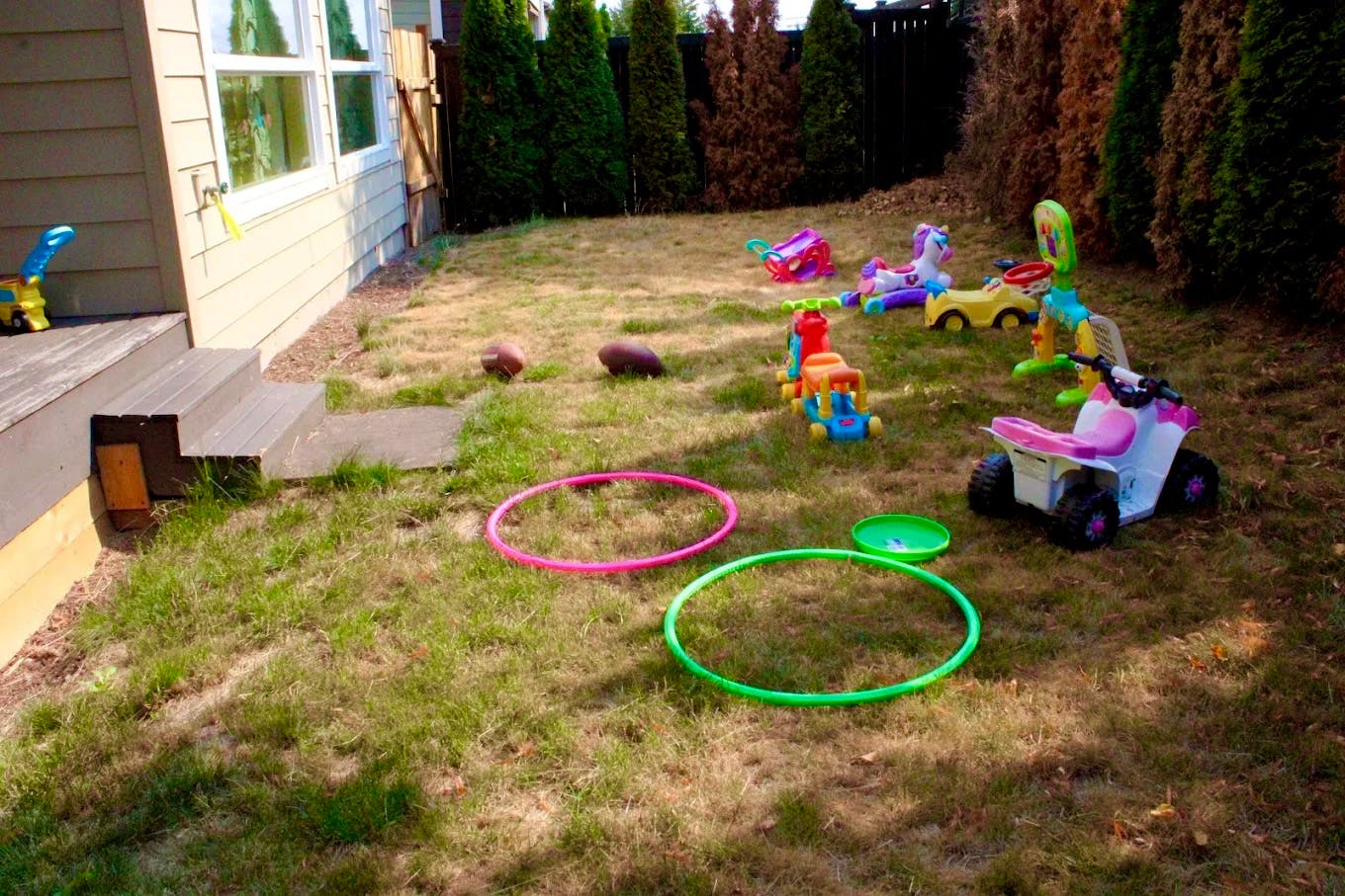Backyard with hula hoops and various toys on the grass