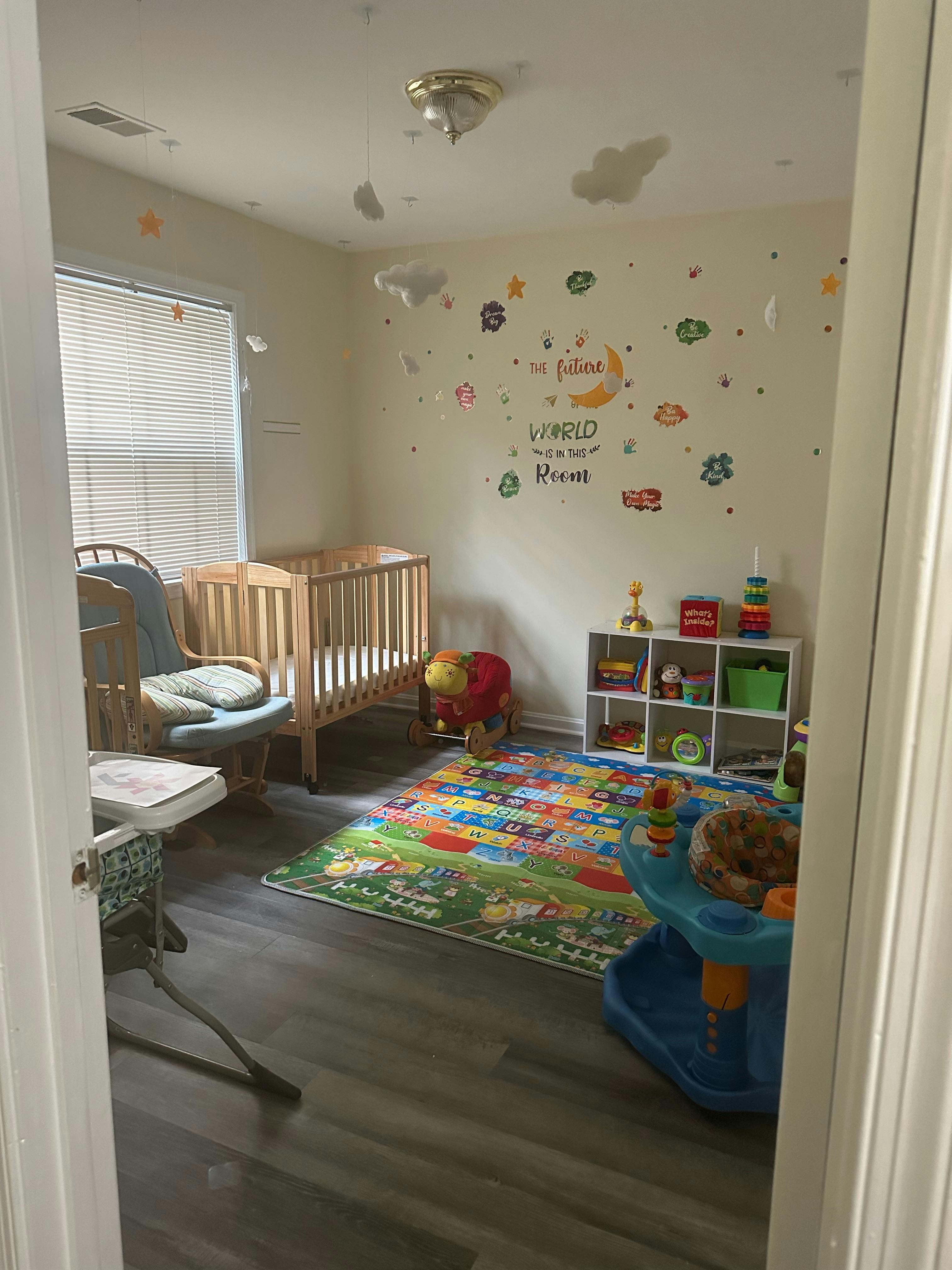 Nursery room with a crib, rocking chair, and colorful play mat